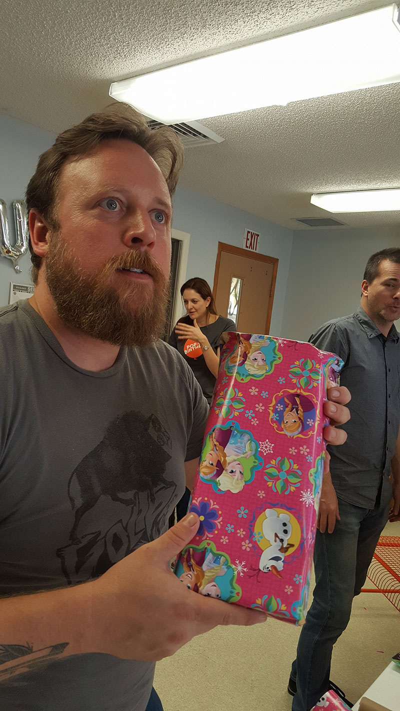 bennu staff at Pop up birthday holding a pink frozen wrapped gift